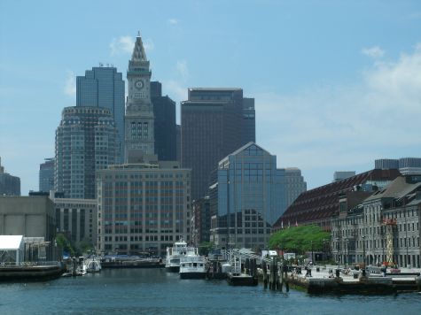 Tall buildings overlooking the harbor and boats docked at the pier