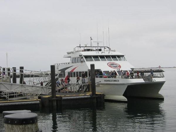 Ferry passengers disembarking from a dual-hulled ferry at the pier in Provincetown